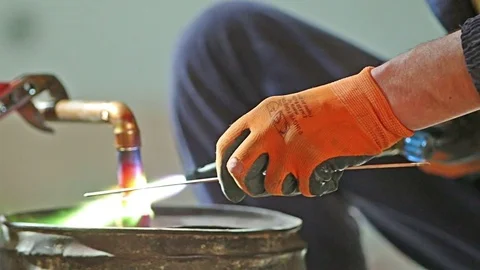 Workers grinding and welding copper pipes in a industrial factory Stock Footage 72962645