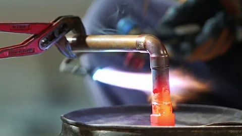 Workers grinding and welding copper pipes in a industrial factory Stock Footage 72962662