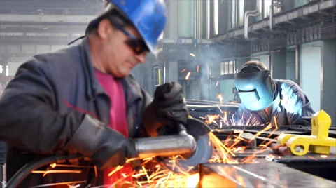 Workers grinding and welding in a factory Stock Footage