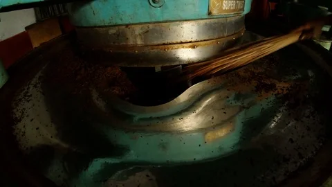 Worker's hand with broom cleans from tea stuff rolling machine old factory Video stock 98757788