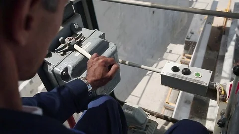 Workers hand contols the crane. Camera closeup inside the cabin. Stock Footage 70208023