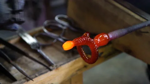 The worker's hand corrects the shape of the workpiece. A billet of a curved Stock Footage 195029438