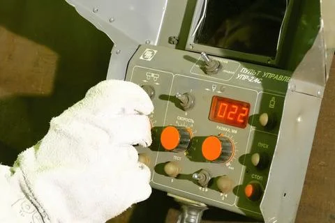 Workers hand in a glove on the control panel of LNG equipment. Stock Photos