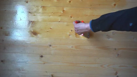 Worker’s hand holds a brush and paints a wooden wall, wall cladding, floor or wa Video stock 98004536