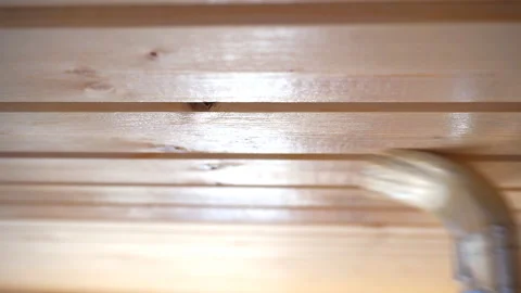 Worker’s hand holds a brush and paints a wooden wall, wall cladding, floor or wa Stock Footage 98004703