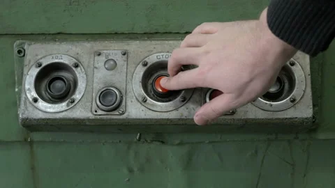 Worker's hand presses the red emergency button on old electrical unit Stock Footage 87725714