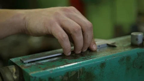 The worker's hand is taking a slide gauge from a metal surface of some appliance Stock Footage 118188534