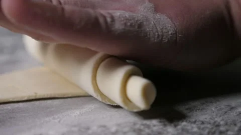 Workers hand twisting up a dought sheet to make a croissant at a bakery plant 스톡 동영상 153300661