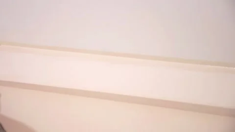 Worker's hand using the brush for the corners along the edge of the ceiling Stock-Footage 132194142