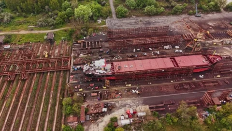 Workers handle large ship parts at the shipyard Vidéo 338324350