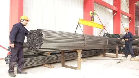 Workers handling a stack of metal pipes at the factory warehouse Stock Footage 95220961