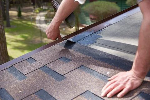 Worker's hands are smeared with waterproofing mastic for the roof. Stock Photos