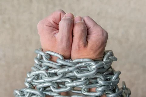 The worker's hands are wrapped in a chain as a concept of slavery or dependence Stock Photos