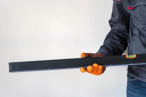 Worker's hands with bubble level. Stock Photos
