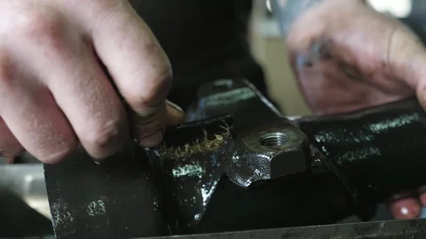 Worker`s hands cleaning a metallic car detail actively with a brush in workshop Video stock 127337436