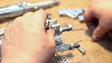 Worker's hands at the factory assemble a metal part from small parts Stock Footage 134201415
