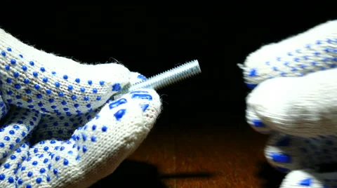 Worker's hands in gloves wind to nut on  bolt. 4K shot macro Vidéo 61793157