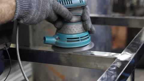 Worker's hands in gray cloth gloves use a metal grinder to process a metal part Stock Footage 133449599