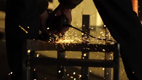 Worker's hands hold a working angle grinder. Stock Footage 171957099