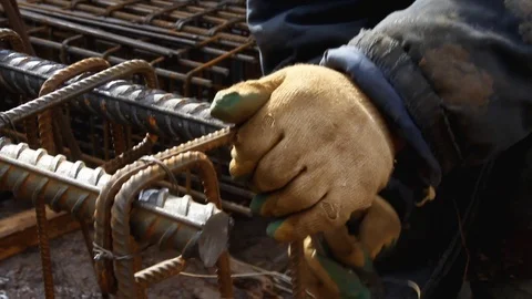 Worker's hands knitting metal rods to each other with wire. Stock Footage 126293423