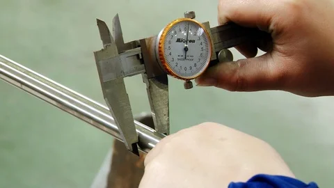 Worker's hands measure thickness of pipe with caliper at the factory. Stock Footage 94411296