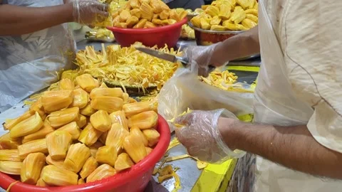 Workers Hands Peeling Ripe Yellow Jackfruit in Busy Tropical Market Stock Footage 327770536