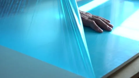 Worker's hands remove the protective film coating Stock Footage 166163314