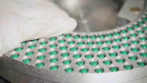 Workers hands removing equipment with blue-green hard shelled capsules Stock Footage 102455523
