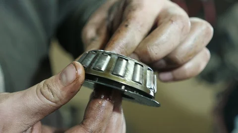 Worker`s hands rotating and cleaning tapered roller bearing in private workshop Video stock 127337623