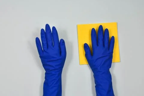 Worker's hands in rubber protective gloves with a rag, wiping the surface of a Stock Photos