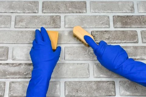 Worker's hands in rubber protective gloves with a rag, wiping the surface of a Stock Photos