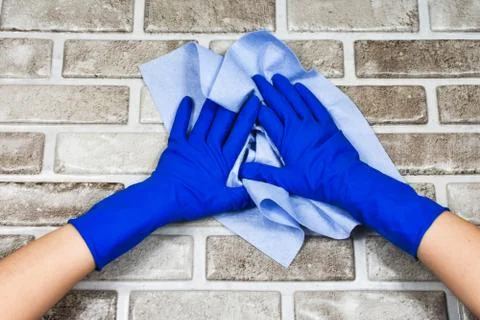 Worker's hands in rubber protective gloves with a rag, wiping the surface of a Stock Photos