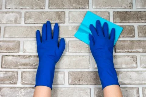Worker's hands in rubber protective gloves with a rag, wiping the surface of a Stock-Fotos