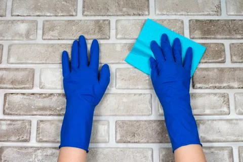 Worker's hands in rubber protective gloves with a rag, wiping the surface of a Stock Photos