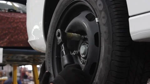 Worker's hands spin the car wheel on the car assembly line Stock Footage 122335840
