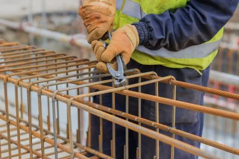 Workers hands using steel wire and pincers to secure rebar Stock Photos