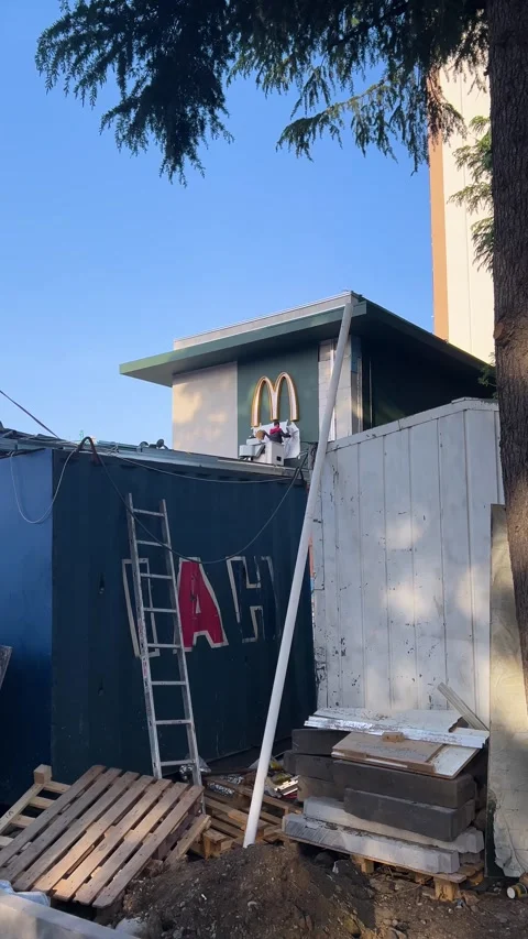 Workers hang logo of fast food restaurant McDonald to wall Stock Footage 309964387