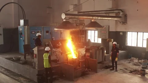 Workers in Hard Hats Operating Molten Metal Furnace Inside Heavy Industrial Stock Footage 334800541