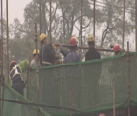 Workers in hard hats work atop low-rise construction site Stock Footage 86744220