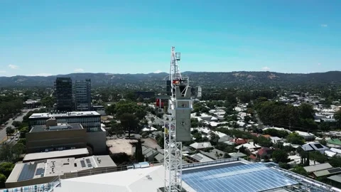 Workers in harnesses dismantle the final sections of a tower crane above Stock Footage 303062355