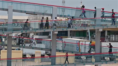 Workers heading to the city on a pedestrian bridge in Dubai, UAE. Stock Footage 341624856