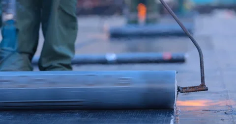 The workers heats the roll of ruberoid with the flame of a gas burner  Stock Footage 119626912