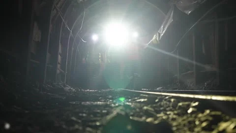Workers with helmets and equipment walking in chrome mine tunnel Stock Footage 241720630