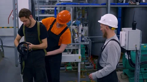 Workers in helmets in the workshop of an industrial production complex, wear Stock Footage 168730943