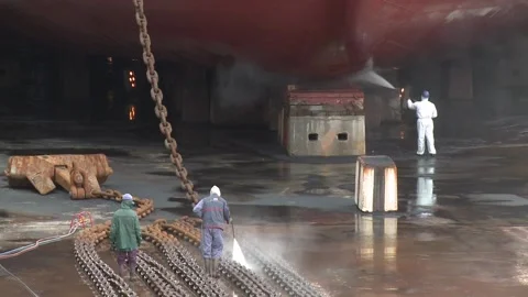Workers high pressure washing rusty anchor chain from ship dry dock slow motion 스톡 동영상 102628903