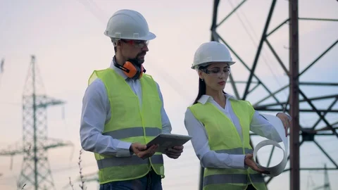 Workers at a high-voltage powerline working with a construction plan. Stock Footage 94017568
