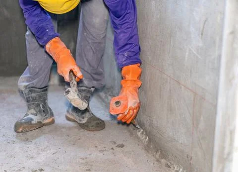Workers hitting hammer on chisel for concrete chipping. Stock-Fotos
