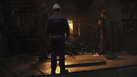 Workers in an Industrial Setting Handling Molten Metal with Expertise and Safety Photos