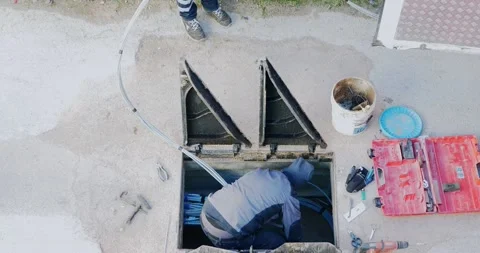Workers insert fiber optic cables into the underground cable ducts to create Video stock 157958494