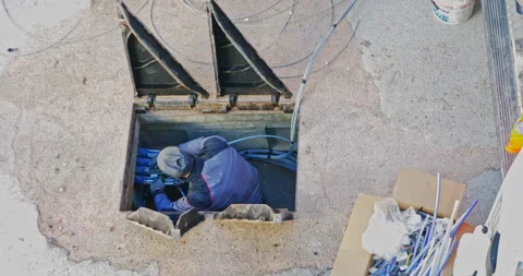 Workers insert fiber optic cables into the underground cable ducts to create  Video stock 196940713